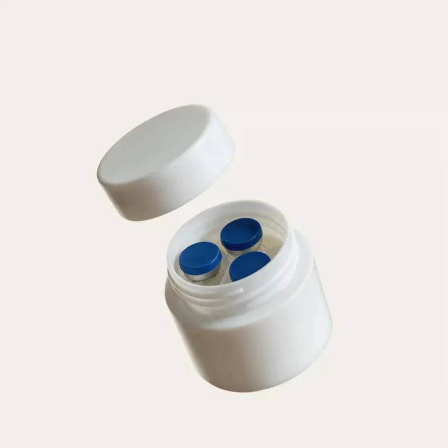 A wide-mouth container opened to show vials with blue closures inside.